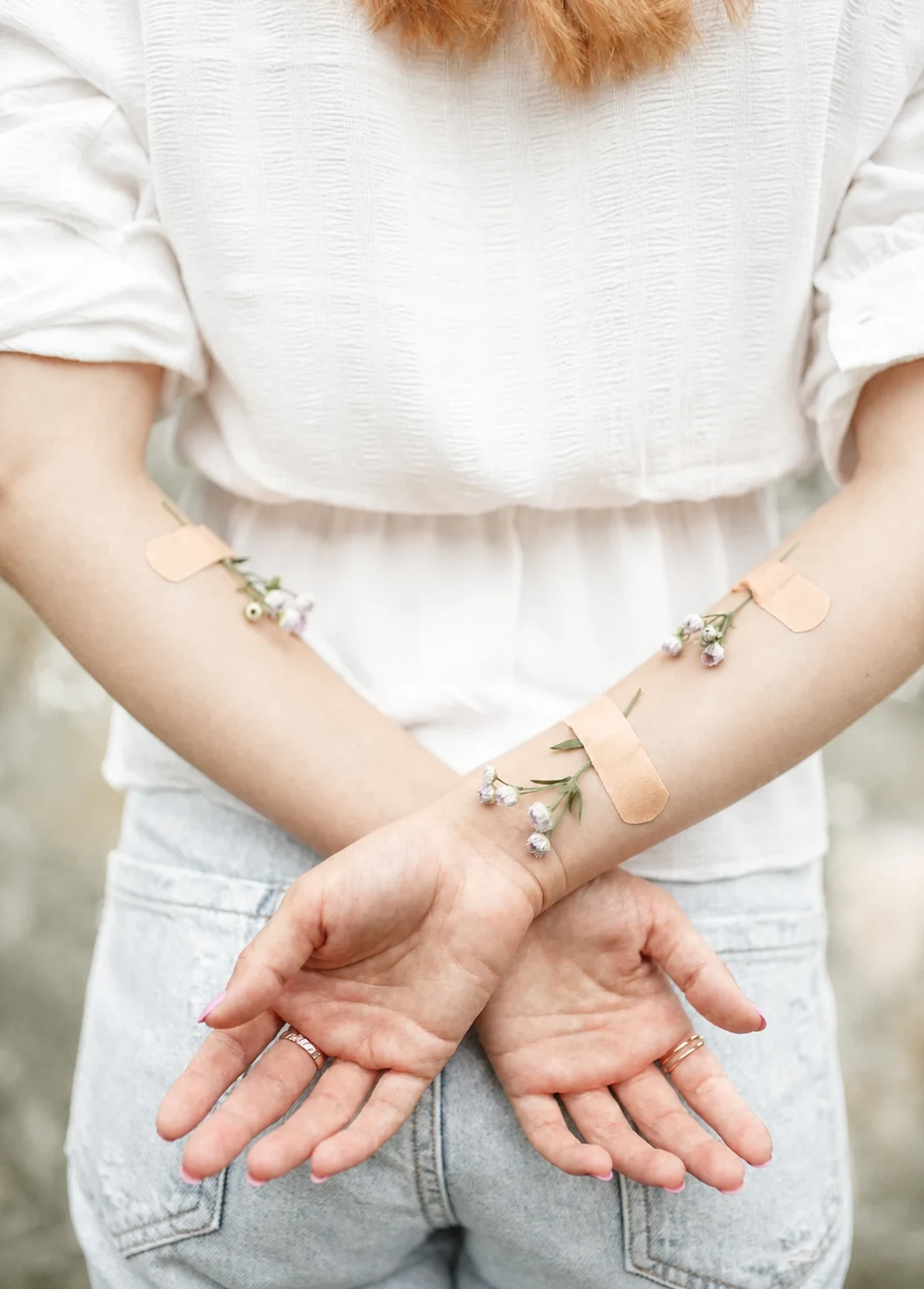 Des mains ouvertes, accompagnées de fleurs et de pansements